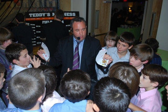 A man in suit and tie talking to children.