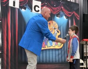 A man and boy in front of a stage.