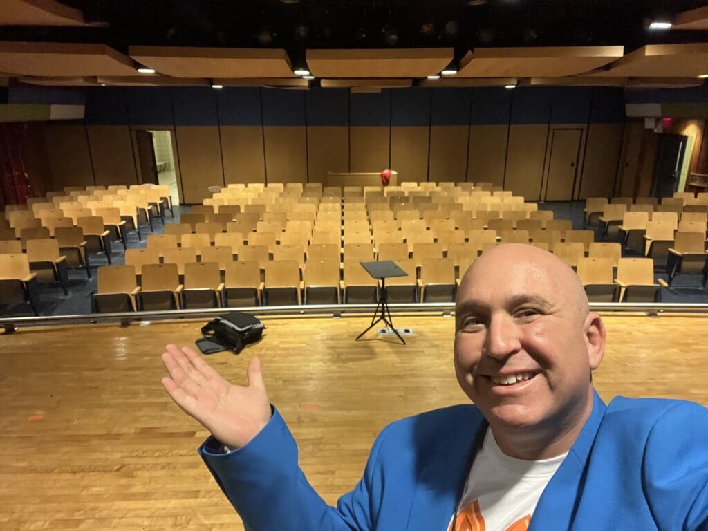 A man in a blue jacket holding up an object.