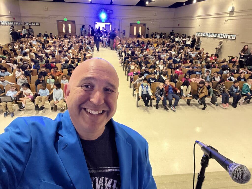 A man in a blue jacket is smiling for the camera.