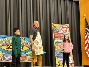 NJ School assembly presenter Michael Kirschner onstage with 2 volunteers during his STEM school assembly