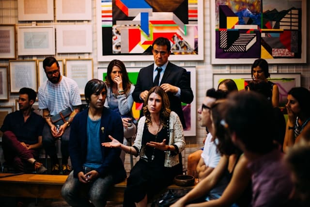 Group of people discussing art in a gallery.