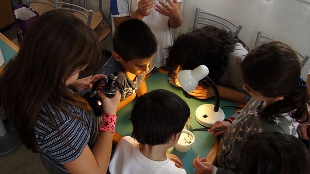 Children working on science project with lamp.