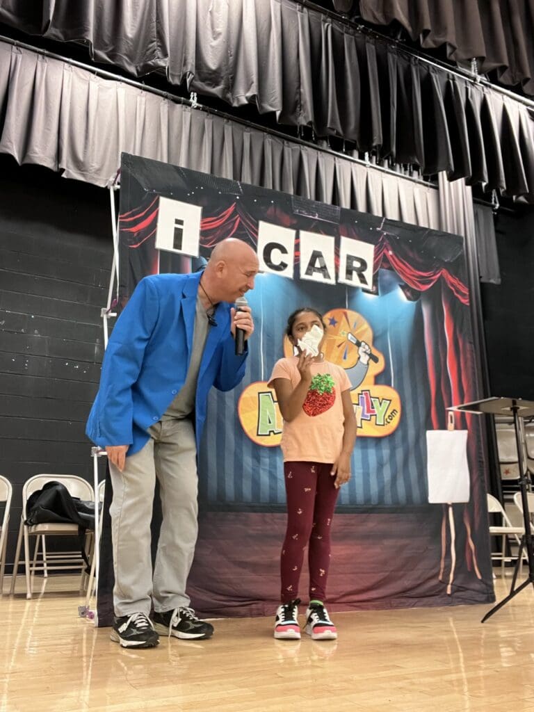 Man in blue jacket and girl on stage.